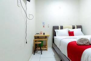 um quarto com uma cama e uma mesa lateral em RedDoorz @ Simpang Pemda Medan em Medan