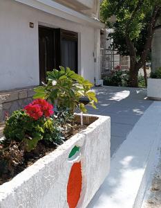 a stone wall with a flower garden in front of a house at Ευρύχωρο και άνετο διαμέρισμα στην Ιτέα Joanna's Apartment in Kírra