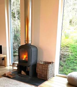 a wood stove in a room with a window at 4 Balvaig Cottage in Stirling
