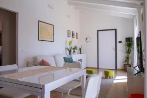 a white living room with a white table and chairs at Waterfront apartment Olbia in Olbia