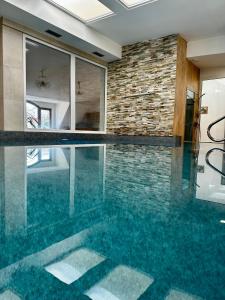 an indoor swimming pool with blue water in a house at LD Morava in Karlovy Vary