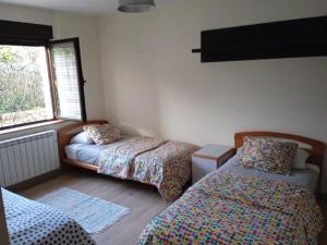 1 dormitorio con 2 camas y ventana en Casa María, en Villaviciosa