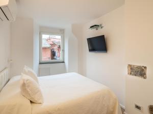 a white bedroom with a bed and a window at White dreams in Portovenere