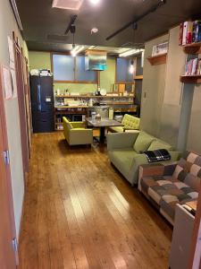 uma sala de estar com dois sofás e uma cozinha em No Borders Hostel em Tóquio