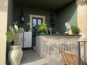a kitchen with green walls and a counter with chairs at Aria Rooms and Terrace in Noto