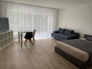 a bedroom with a bed and a table and a couch at Weststadt Apartment in Baden-Baden