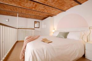 Un dormitorio con una cama blanca con un libro. en Villa Fiorita, en Cattolica
