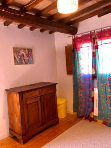 a room with two curtains and a wooden cabinet at Tenuta di Corsano in Monteroni dʼArbia