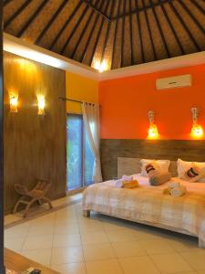 a bedroom with orange walls and a large bed at Arco Iris Boutique Hotel & Restaurant in Candidasa