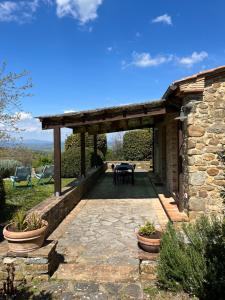 a stone house with a patio with a table at Podere Prataccio in Grosseto
