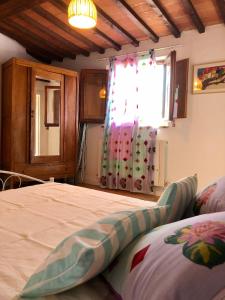 a bedroom with a large bed with a window at Tenuta di Corsano in Monteroni dʼArbia