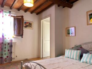 モンテローニ・ダルビアにあるTenuta di Corsanoのベッドルーム1室(ベッド1台付)、窓、ドアが備わります。