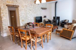 uma sala de jantar com uma mesa de madeira e cadeiras em Charme au cœur des vignes em Malras