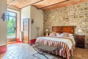 1 dormitorio con cama y pared de piedra en Villa Unica Sant'Alberto, en Campiglia dʼOrcia
