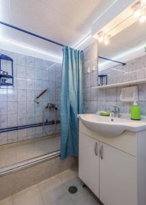 uma casa de banho com um lavatório e um chuveiro em Blue Traditional Boathouse in Klima em Klima