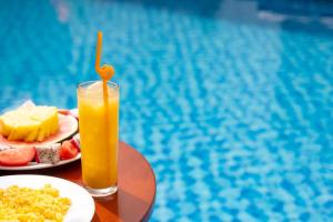 een tafel met een bord eten en een glas sinaasappelsap bij Haemer Villa Green Hearth Stay in Hội An