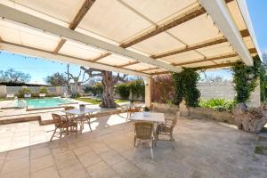 patio con tavolo, sedie e ombrellone di Dependance di Omero by BarbarHouse a Cavallino di Lecce