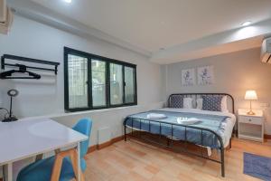 1 dormitorio con 1 cama, mesa y sillas en Bangkok Watergate Townhouse 曼谷中心水門家 en Bangkok