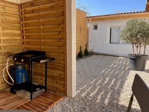a backyard with a wooden fence and a grill at La Belle Endormie - Louez L'Esprit Libre ! in Champs-sur-Marne