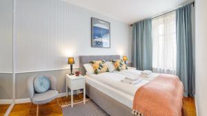 um quarto com uma cama, uma cadeira e uma janela em Apartamenty Sun & Snow Karlikowo em Sopot