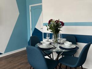 una sala da pranzo con tavolo e sedie blu di Modern accomodation in Westcliff-On-Sea a Westcliff-on-Sea