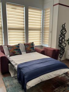 a bed sitting in a room with windows at Modern accomodation in Westcliff-On-Sea in Westcliff-On-Sea