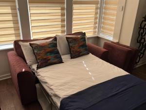 a bed with two pillows on it in a room at Modern accomodation in Westcliff-On-Sea in Westcliff-On-Sea