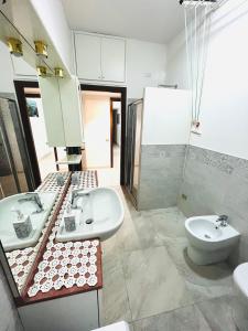ein Badezimmer mit zwei Waschbecken und einem WC in der Unterkunft grazioso bilocale a 100 mt dalla metropolitana in Sesto San Giovanni