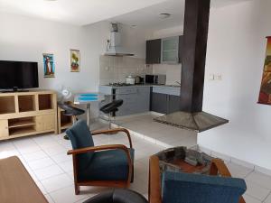 a living room with a kitchen with a stove at Aina Hôtel in Antananarivo
