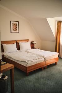 a bedroom with a large bed with white sheets at Hotel Exel in Amstetten