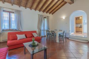 un soggiorno con divano rosso e tavolo di Ca' Mia by Wonderful Italy a Menaggio
