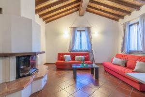 un soggiorno con 2 divani rossi e un camino di Ca' Mia by Wonderful Italy a Menaggio