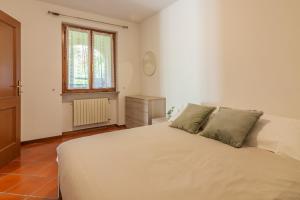 una camera con un letto bianco e una finestra di Ca' Mia by Wonderful Italy a Menaggio