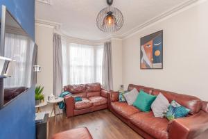 a living room with a brown leather couch at Leeds 4-Bed House - Sleeps 9 Free Parking & WiFi in Leeds
