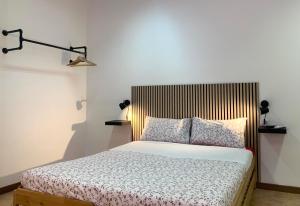 1 dormitorio con 1 cama con cabecero de madera en Cascina Bellaria, en Milán