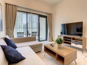 sala de estar con sofá y TV de pantalla plana en Key View - Burj Royale, en Dubái