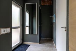een hal met een deur en een spiegel bij Vrijburgstraat 10 in Vlissingen