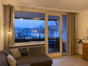 - un salon avec un canapé et une grande fenêtre dans l'établissement Ferienwohnung Morgensonne, à Oberstaufen