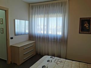 - une chambre avec un lit, une commode et une fenêtre dans l'établissement NSM Casa di Fulmine, à Foggia