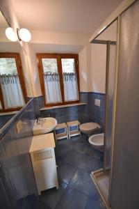 a bathroom with two sinks and a shower and two toilets at Appartamento Cavoli - Vista mare con terrazza, clima e posto auto in Cavoli +61 photos