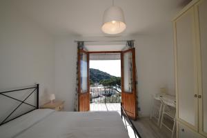 a bedroom with a bed and a door to a balcony at Appartamento Cavoli - Vista mare con terrazza, clima e posto auto in Cavoli