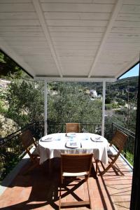 a white table and chairs on a deck with a view at Appartamento Cavoli - Vista mare con terrazza, clima e posto auto in Cavoli