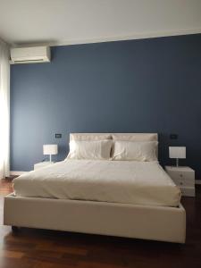 1 dormitorio con cama blanca y pared azul en Fancy Monique en Milán