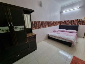 een kleine slaapkamer met een bed en een dressoir bij HELLO HOMESTAY in Nibung Tebal