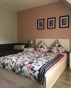 1 dormitorio con 1 cama con edredón de flores en SEWANA Pokoje Gościnne i Domki Letniskowe, en Mikołajki