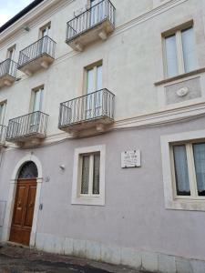 un bâtiment blanc avec des balcons sur le côté dans l'établissement Casa Giulia, à LʼAquila