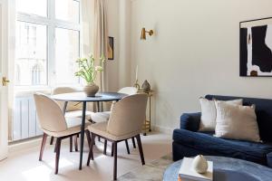 a living room with a table and chairs and a couch at The City of London Secret - Classy 1BDR Flat in London