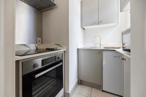 a small kitchen with a sink and a dishwasher at The City of London Secret - Classy 1BDR Flat in London