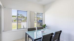 a dining room with a glass table and two chairs at Sunnyvale 2 - Pet Friendly in Yamba