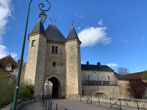 un antico edificio in pietra con cancello e lampione di Maison de campagne bourguignonne 19ème entièrement rénovée a Chaumot